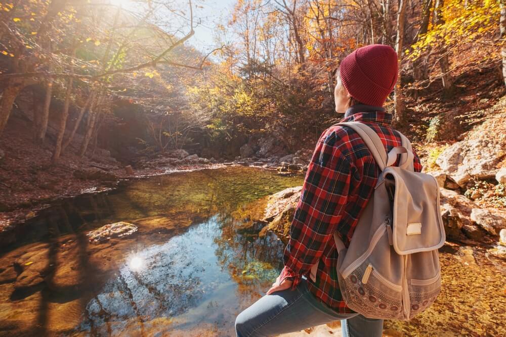 A woman hiking, one of the best things to do when visiting Maine in the fall.