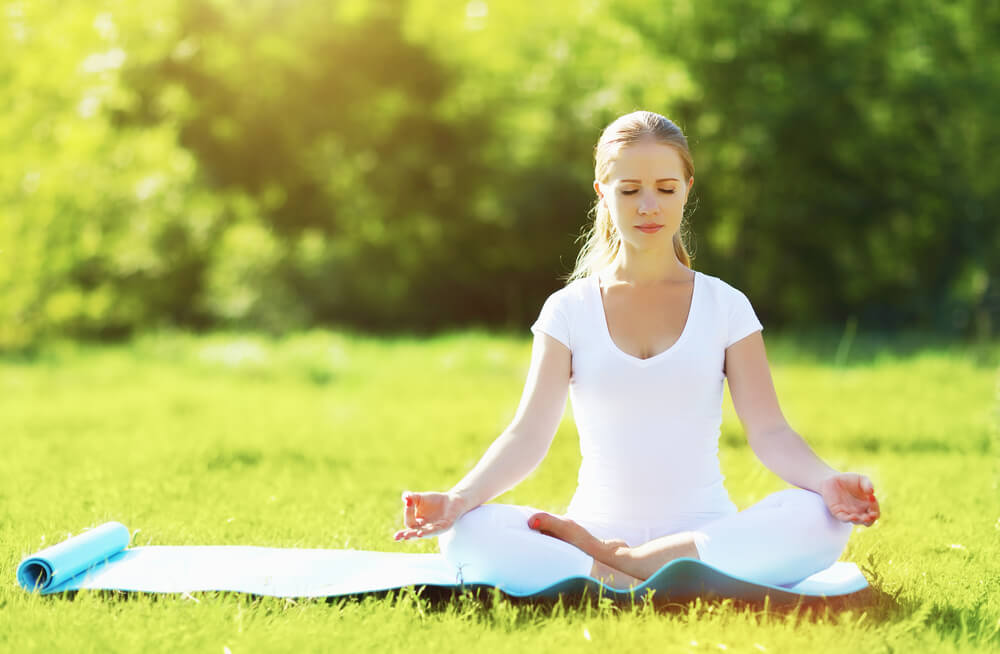 A woman meditating on a wellness retreat in Midcoast Maine.