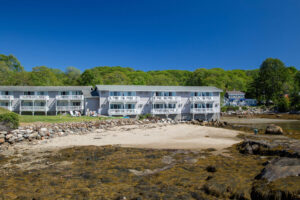 A view of the beach and a building at a Boothbay Harbor resort that's close to some of the best are cruises.