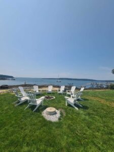 The firepit area of a hotel near Boothbay Harbor where you can see a local schooner sail by.