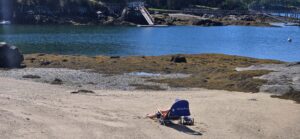 A person relaxing on the beach, one of the best things to do in Midcoast Maine on a solo vacation.